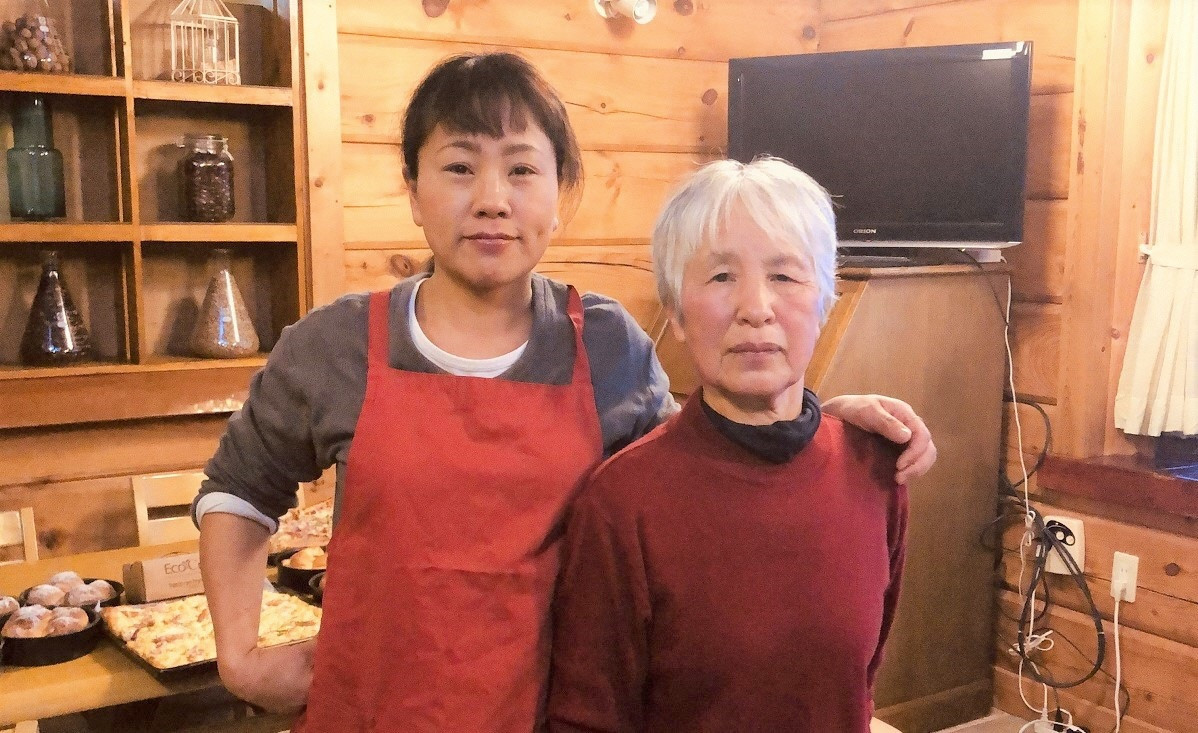ミニトマトジュースを製造する鈴木さん(左)