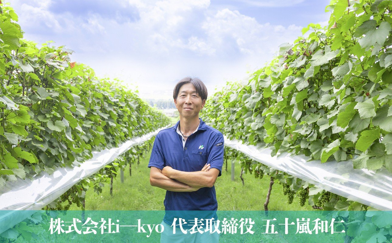 株式会社i-kyo 代表取締役 五十嵐和仁氏。背景には水沢の広大なぶどう畑が広がっている
