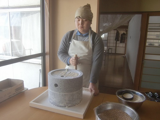 石臼を使い、大麦をひいている様子です。手作業で丁寧にひいています。