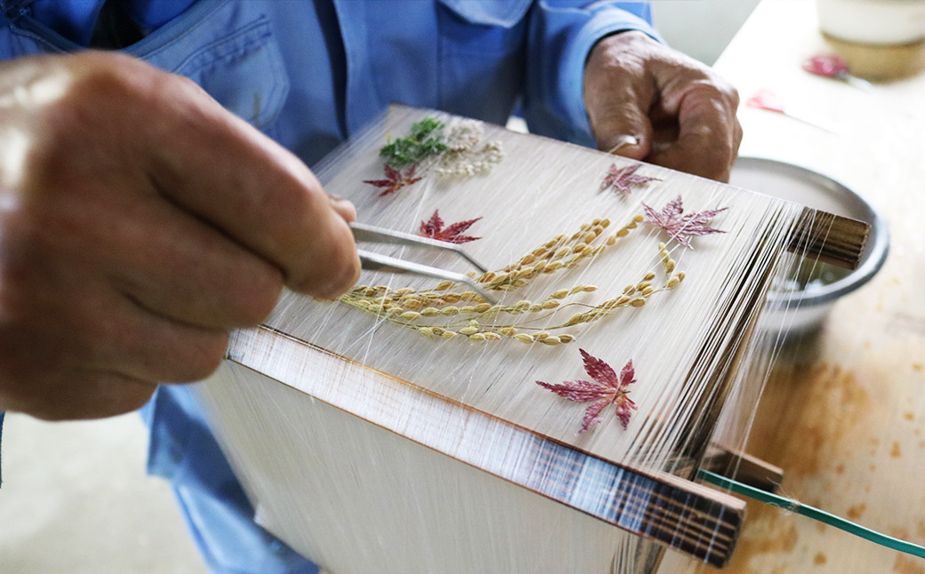 天然の押し花や葉を一つ一つ織り込み巻きつけています。