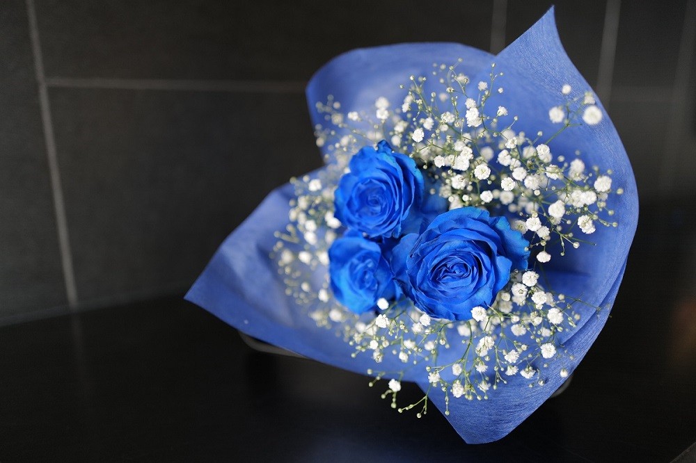 青いバラとかすみ草の花束です。
青いバラの花言葉は「可能性」、3本のバラの花言葉は「愛しています」です。