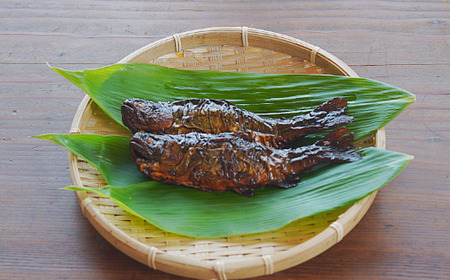 「虹鱒の甘露煮（ニジマスノカンロニ）10尾入り」 黒姫山麓の養鱒場（ヨウソン）を営む親子三代受け継ぐ伝統製法。≪一尾ずつ串打ち → 素焼き → 低温9時間煮込→一晩寝かせて→甘露煮（味入れ）仕上げ≫ 